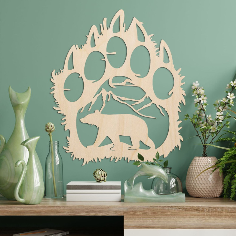 Kontrastná silueta medvedej stopy, vnútri ktorej je vidieť horský masív a postavu medveďa kráčajúceho vpred.