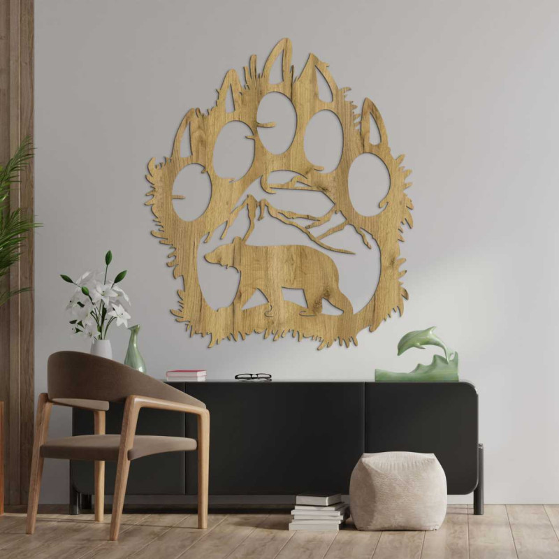 Ručne vyrezávaná dekorácia znázorňujúca medveďa kráčajúceho pod horským masívom.