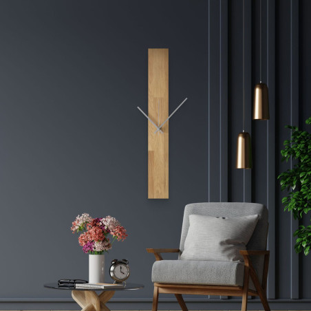 Moderné nástenné hodiny, nalepené na bielej stene, s jednoduchými čiernymi ručičkami. Moderné nástenné hodiny, nalepené na bielej stene, s jednoduchými čiernymi ručičkami.